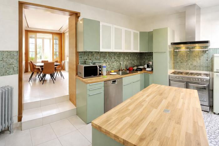 🔷 FR 🔶Transition douce entre les lignes épurées de la cuisine design et l'héritage magistral dans la salle à manger suivi du salon 🔱 NL ⚜️ Een moeiteloze overgang  tussen de strakke lijnen van de designkeuken en het grootse erfgoed van de eetkamer, die overgaat in de salon  🧡 EN 💛 A seamless transition that takes no sides between the clean lines of a modern kitchen and the grand heritage of the dining room, leading into the living room.