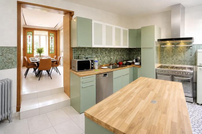 🔷 FR 🔶Transition douce entre les lignes épurées de la cuisine design et l'héritage magistral dans la salle à manger suivi du salon 🔱 NL ⚜️ Een moeiteloze overgang  tussen de strakke lijnen van de designkeuken en het grootse erfgoed van de eetkamer, die overgaat in de salon  🧡 EN 💛 A seamless transition that takes no sides between the clean lines of a modern kitchen and the grand heritage of the dining room, leading into the living room.