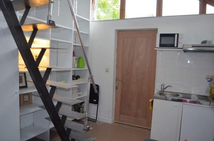 Vue sur escalier vers mezzanine, espaces de rangement, coin kitchenette et entrée privative